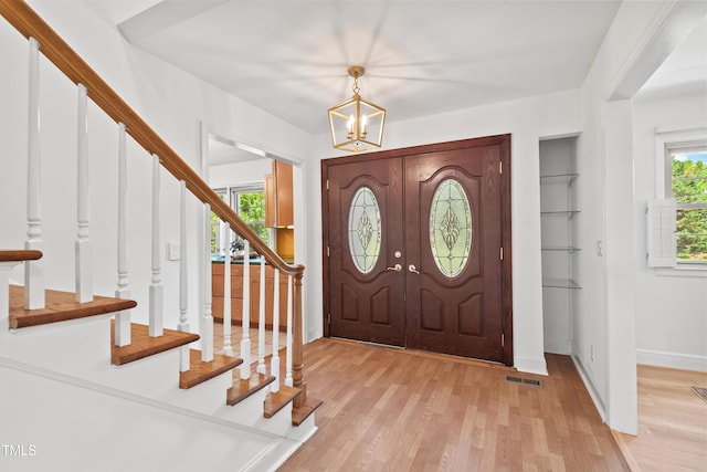 307 Country Club Dr, Durham, NC 27712 - foyer entrance with stairs, light wood-style flooring, a chandelier, and baseboards