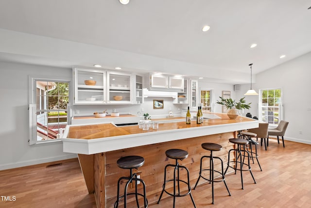 307 Country Club Dr, Durham, NC 27712 - kitchen with light wood-style flooring, recessed lighting, baseboards, white cabinets, and glass insert cabinets