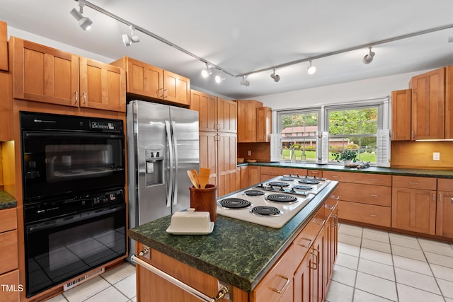 307 Country Club Dr, Durham, NC 27712 - kitchen with electric cooktop, stainless steel refrigerator with ice dispenser, light tile patterned floors, a kitchen island, and dark countertops