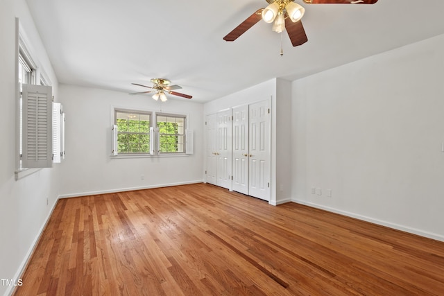 307 Country Club Dr, Durham, NC 27712 - unfurnished bedroom featuring multiple closets, light wood-style floors, baseboards, and a ceiling fan