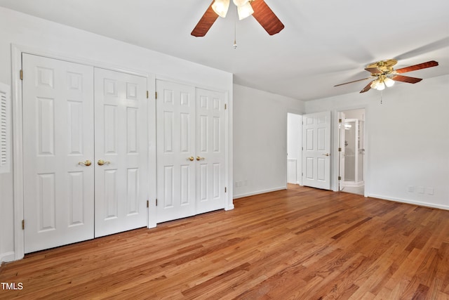 307 Country Club Dr, Durham, NC 27712 - unfurnished bedroom featuring multiple closets, light wood-type flooring, baseboards, and ceiling fan
