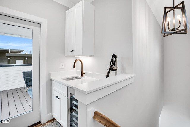 606 Velma Hopkins Ln, Raleigh, NC 27603 - bar with a sink, wine cooler, a chandelier, hanging light fixtures, and wood finished floors