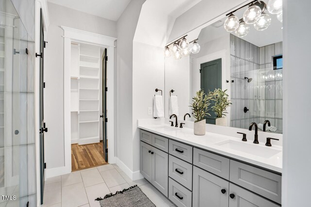 606 Velma Hopkins Ln, Raleigh, NC 27603 - bathroom with a shower stall, double vanity, a chandelier, a walk in closet, and tile patterned floors