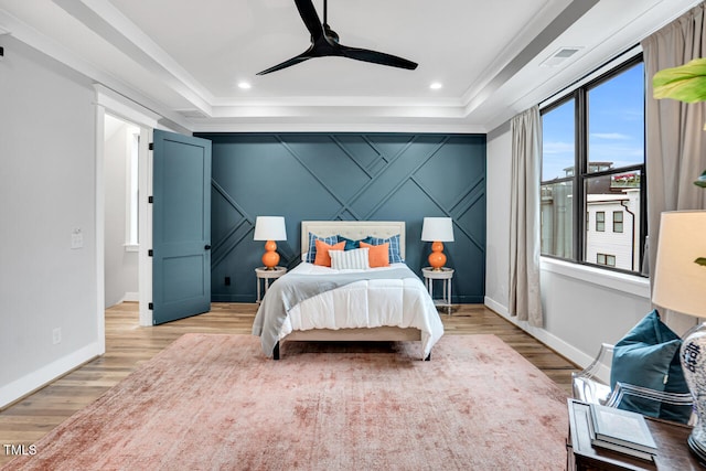 606 Velma Hopkins Ln, Raleigh, NC 27603 - bedroom with a tray ceiling, light wood-type flooring, baseboards, crown molding, and ceiling fan