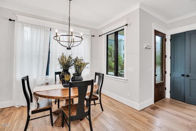 606 Velma Hopkins Ln, Raleigh, NC 27603 - dining area with a chandelier, baseboards, light wood-style flooring, and crown molding