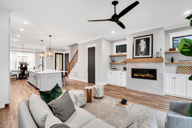 606 Velma Hopkins Ln, Raleigh, NC 27603 - living area with light wood-style floors, a ceiling fan, stairway, recessed lighting, and a tile fireplace