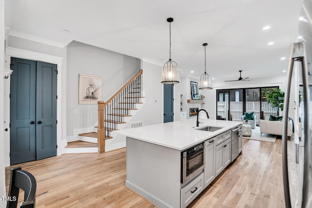 606 Velma Hopkins Ln, Raleigh, NC 27603 - kitchen with a sink, a ceiling fan, appliances with stainless steel finishes, open floor plan, and light wood-type flooring