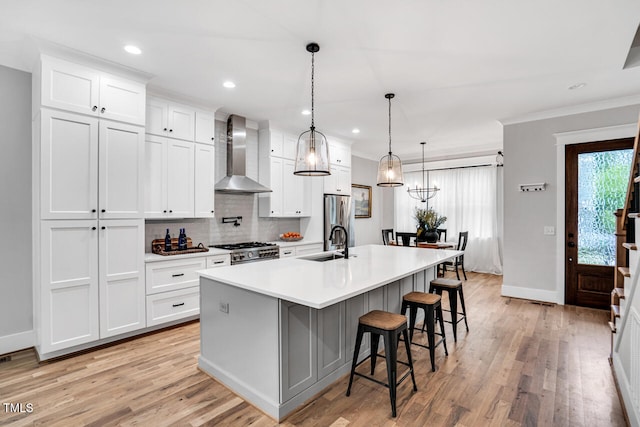 606 Velma Hopkins Ln, Raleigh, NC 27603 - kitchen featuring wall chimney exhaust hood, range, a sink, a spacious island, and freestanding refrigerator