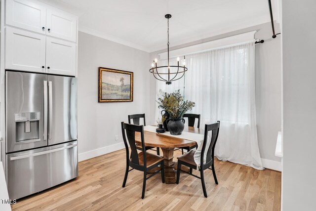 606 Velma Hopkins Ln, Raleigh, NC 27603 - dining space featuring baseboards, a chandelier, and light wood-style floors
