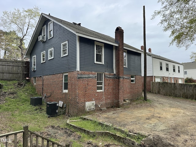 2503 Chapel Hill Rd, Durham, NC 27707 - rear view of property featuring a chimney, brick siding, cooling unit, and central AC