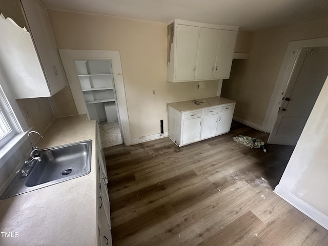 2503 Chapel Hill Rd, Durham, NC 27707 - kitchen featuring a sink, wood finished floors, white cabinetry, and light countertops