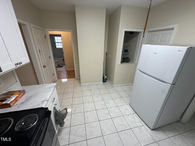 2505 Chapel Hill Rd, Durham, NC 27707 - kitchen featuring freestanding refrigerator, black / electric stove, white cabinets, and light marble finish floors