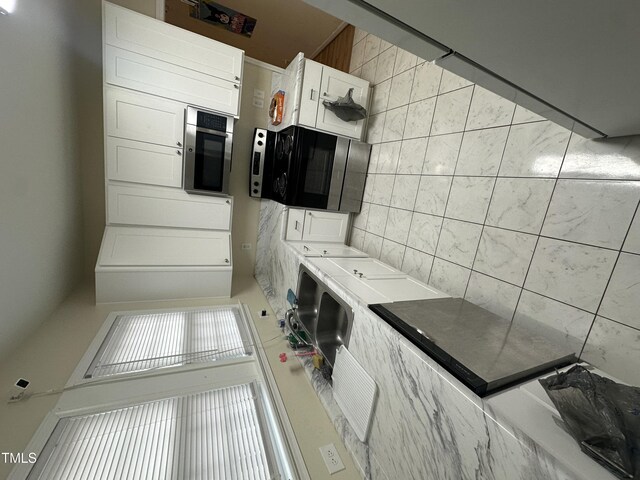2505 Chapel Hill Rd, Durham, NC 27707 - kitchen featuring black microwave, white cabinetry, and backsplash