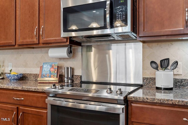 228 Ellisview Dr, Cary, NC 27519 - kitchen featuring appliances with stainless steel finishes, brown cabinets, decorative backsplash, and stone countertops
