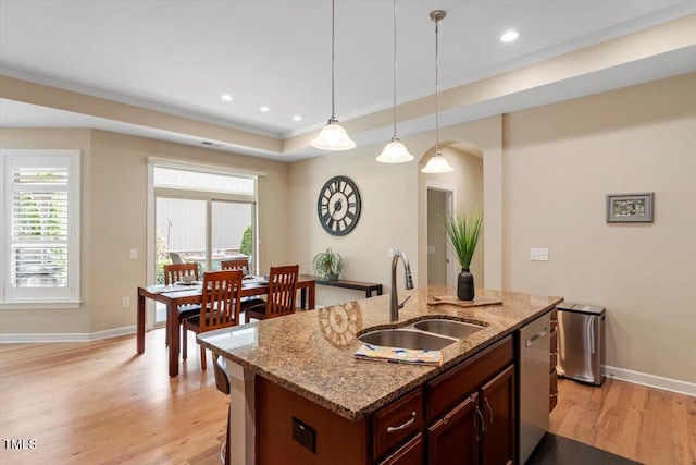 228 Ellisview Dr, Cary, NC 27519 - kitchen with a sink, light wood-style flooring, arched walkways, hanging light fixtures, and crown molding