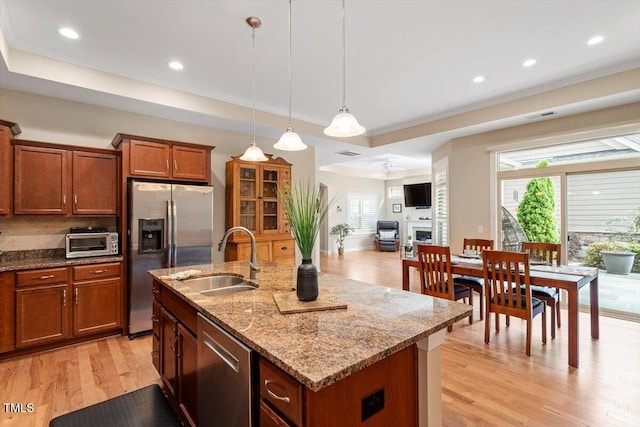 228 Ellisview Dr, Cary, NC 27519 - kitchen featuring stainless steel appliances, a sink, light wood finished floors, brown cabinetry, and crown molding