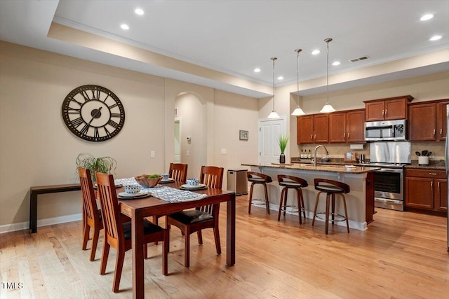 228 Ellisview Dr, Cary, NC 27519 - dining space featuring crown molding, arched walkways, light wood-type flooring, recessed lighting, and baseboards