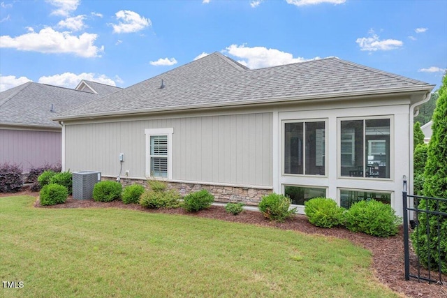228 Ellisview Dr, Cary, NC 27519 - view of home's exterior featuring central AC unit, a yard, stone siding, and roof with shingles