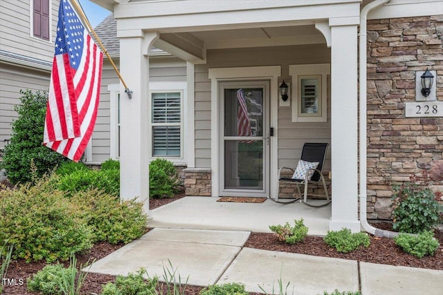 228 Ellisview Dr, Cary, NC 27519 - doorway to property with covered porch, stone siding, and a shingled roof