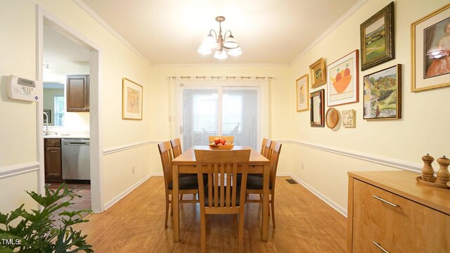 516 Ryan Rd, Cary, NC 27511 - dining room featuring light wood finished floors, a chandelier, crown molding, and baseboards
