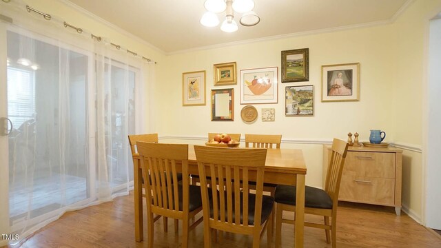 516 Ryan Rd, Cary, NC 27511 - dining area with light wood finished floors, crown molding, and a chandelier