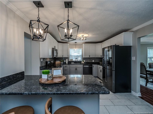 5307 N Fayetteville Rd, Lumberton, NC 28360 - kitchen featuring black appliances, a chandelier, a peninsula, decorative backsplash, and decorative light fixtures
