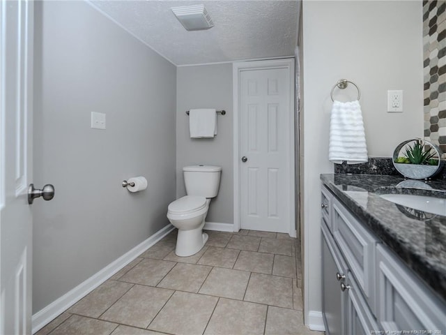 5307 N Fayetteville Rd, Lumberton, NC 28360 - bathroom with vanity, toilet, a textured ceiling, tile patterned flooring, and baseboards
