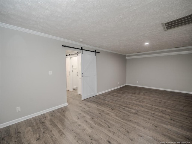 5307 N Fayetteville Rd, Lumberton, NC 28360 - unfurnished room featuring a textured ceiling, wood finished floors, baseboards, a barn door, and crown molding
