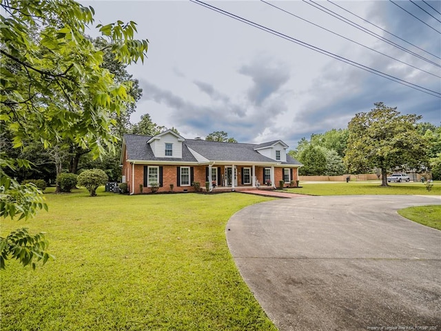 5307 N Fayetteville Rd, Lumberton, NC 28360 - cape cod-style house with brick siding, curved driveway, a porch, and a front lawn