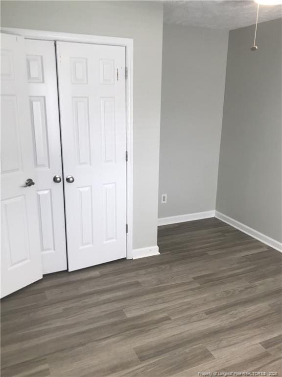 330 Bubble Creek Ct Unit 8, Fayetteville, NC 28311 - unfurnished bedroom featuring baseboards, a closet, and wood finished floors