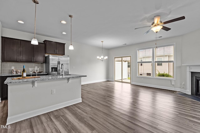 1102 Latitude Dr, Durham, NC 27713 - kitchen featuring stainless steel fridge with ice dispenser, a fireplace with flush hearth, dark wood finished floors, dark brown cabinets, and open floor plan