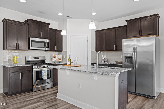 1102 Latitude Dr, Durham, NC 27713 - kitchen with appliances with stainless steel finishes, a sink, wood finished floors, tasteful backsplash, and recessed lighting