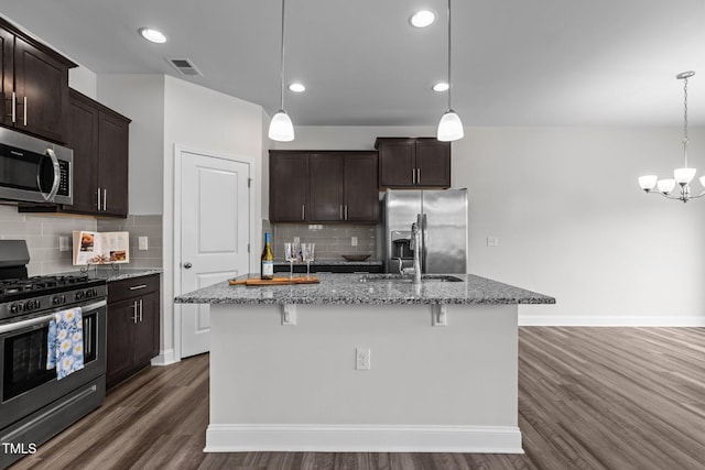 1102 Latitude Dr, Durham, NC 27713 - kitchen with appliances with stainless steel finishes, light stone countertops, dark brown cabinetry, dark wood-style flooring, and recessed lighting