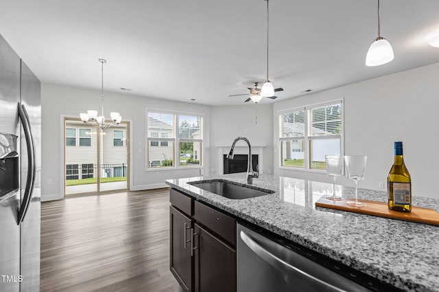 1102 Latitude Dr, Durham, NC 27713 - kitchen with stainless steel appliances, a fireplace, a sink, a ceiling fan, and decorative light fixtures