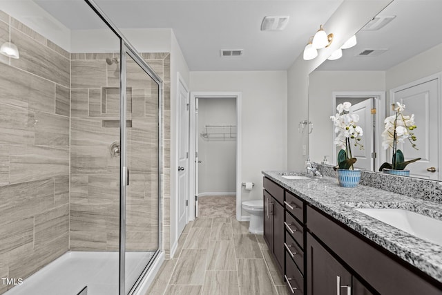 1102 Latitude Dr, Durham, NC 27713 - full bath with double vanity, a stall shower, toilet, baseboards, and a walk in closet