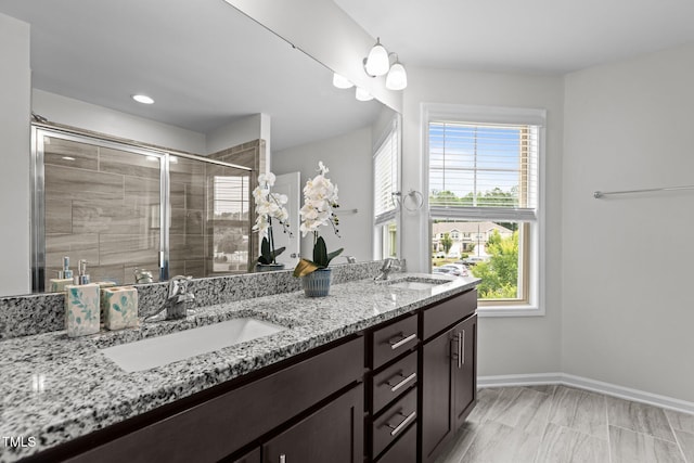 1102 Latitude Dr, Durham, NC 27713 - full bathroom with double vanity, a shower stall, healthy amount of natural light, and baseboards