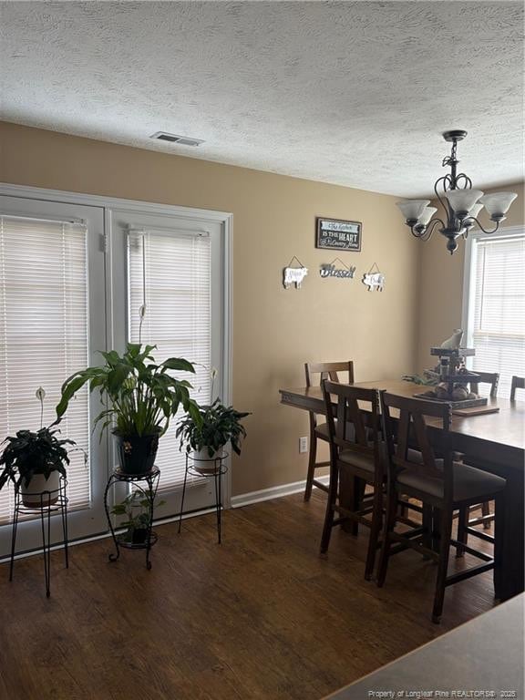 135 Paulownia Dr, Saint Pauls, NC 28384 - dining area featuring wood finished floors, a chandelier, a textured ceiling, and baseboards