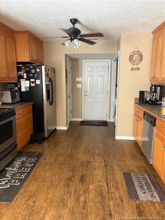 135 Paulownia Dr, Saint Pauls, NC 28384 - kitchen with stainless steel appliances, washer / dryer, a ceiling fan, a textured ceiling, and dark wood-style flooring