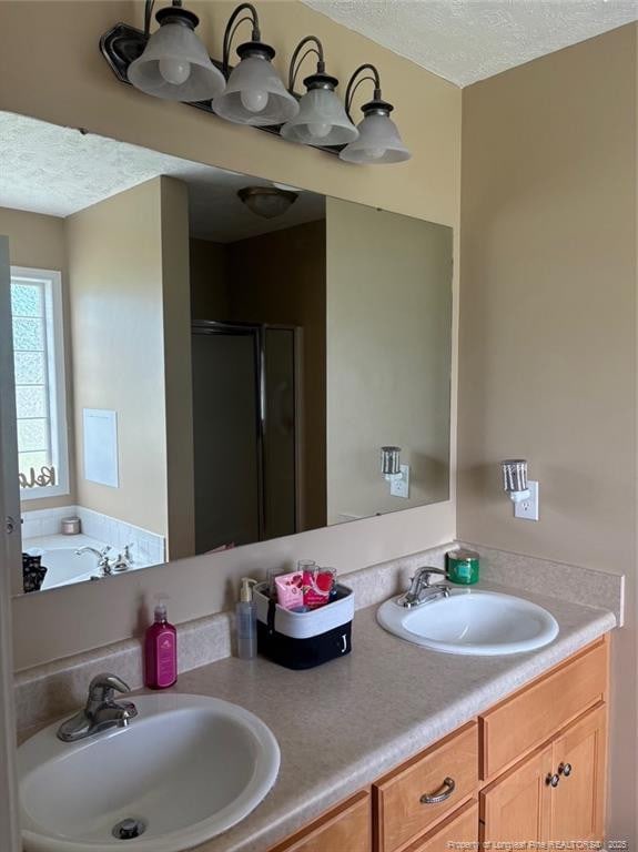 135 Paulownia Dr, Saint Pauls, NC 28384 - bathroom featuring a textured ceiling, a stall shower, double vanity, and a garden tub