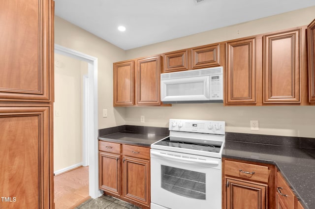 3027 Maple Ave Unit A-1, Burlington, NC 27215 - kitchen with white appliances, brown cabinetry, recessed lighting, and dark stone countertops