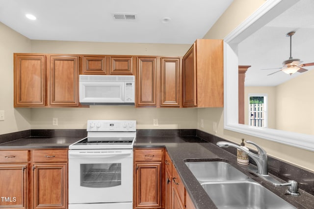 3027 Maple Ave Unit A-1, Burlington, NC 27215 - kitchen featuring white appliances, a sink, brown cabinetry, ceiling fan, and dark stone counters