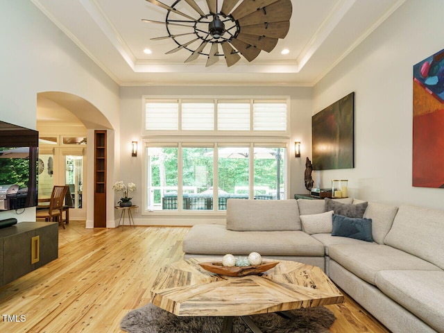 410 Mountain Laurel, Chapel Hill, NC 27517 - living room featuring arched walkways, a tray ceiling, light wood-style floors, ornamental molding, and a high ceiling