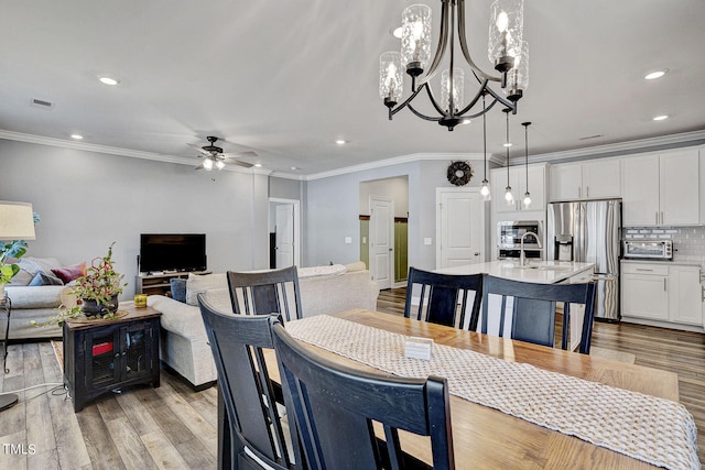244 Chateau Way, Angier, NC 27501 - dining room featuring a ceiling fan, light wood finished floors, a chandelier, crown molding, and recessed lighting