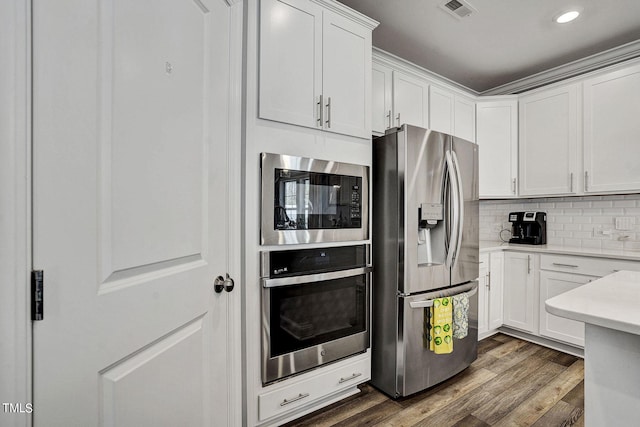 244 Chateau Way, Angier, NC 27501 - kitchen with stainless steel appliances, light countertops, white cabinetry, dark wood finished floors, and backsplash