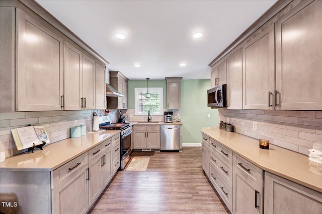 750 Greenleaf Rd, Angier, NC 27501 - kitchen with appliances with stainless steel finishes, a sink, ventilation hood, light wood-style floors, and decorative backsplash