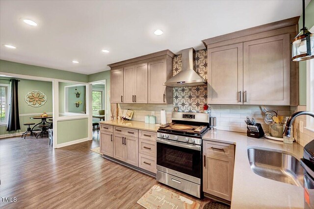 750 Greenleaf Rd, Angier, NC 27501 - kitchen featuring wall chimney exhaust hood, gas stove, a sink, light wood finished floors, and light countertops