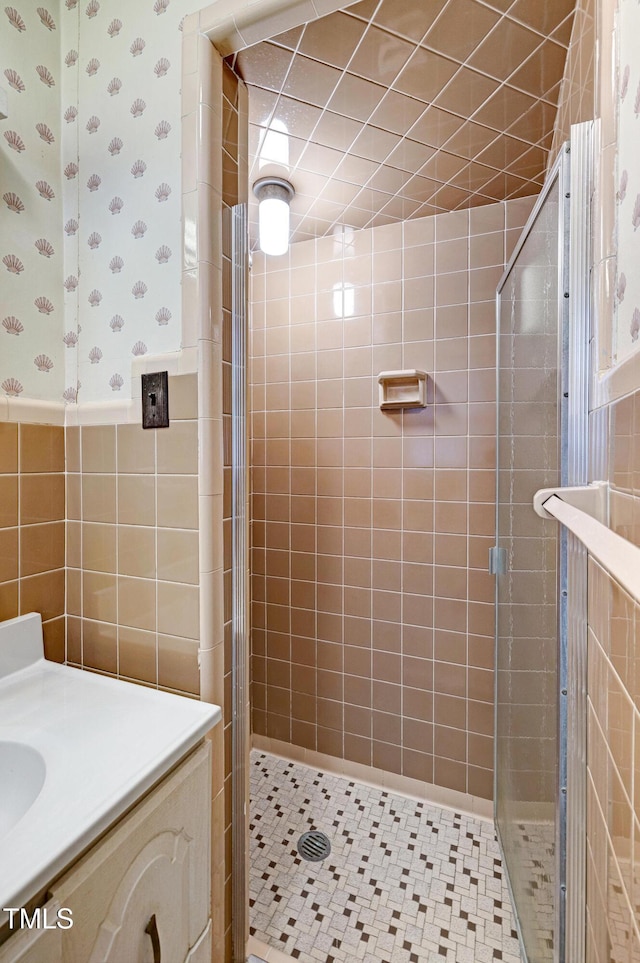 2016 Tryon Rd, Raleigh, NC 27603 - bathroom with a shower stall, wallpapered walls, vanity, tile walls, and wainscoting