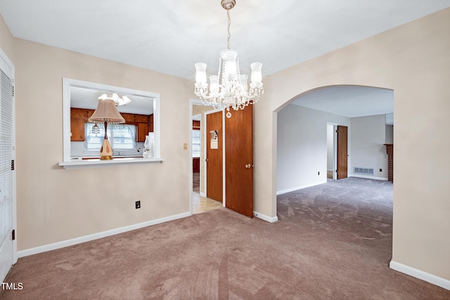 2016 Tryon Rd, Raleigh, NC 27603 - empty room with arched walkways, a chandelier, carpet floors, and baseboards