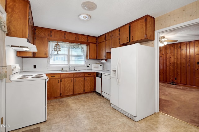 2016 Tryon Rd, Raleigh, NC 27603 - kitchen with white appliances, under cabinet range hood, a sink, light floors, and ceiling fan