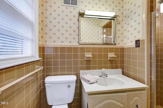 2016 Tryon Rd, Raleigh, NC 27603 - bathroom featuring wallpapered walls, a wainscoted wall, toilet, vanity, and tile walls